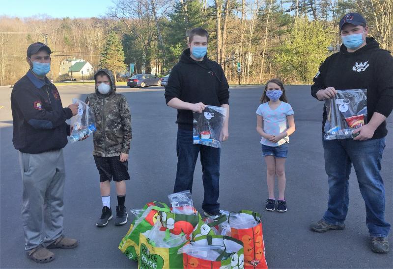 Action For Animals youth volunteers Kale Rogers, second from left, and Isabella Lockesmith present treat bags to a few junior firefighers at the Boothbay Fire Station May 13. LISA KRISTOFF/Boothbay Register