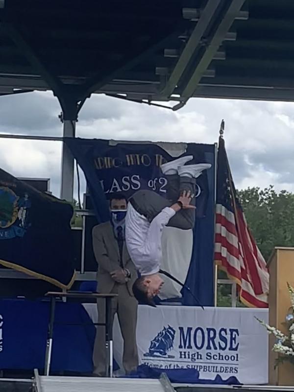 Getting his diploma, a graduating senior does a backflip as Principal Eric Varney looks on. SUSAN JOHNS/Wiscasset Newspaper