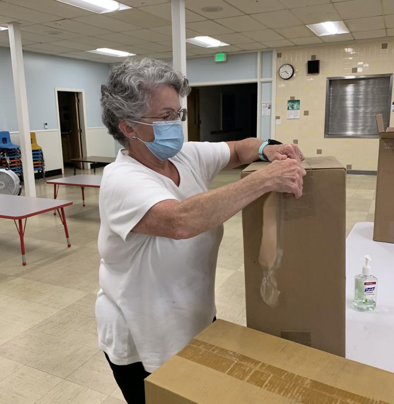 Peg Maguire opens a box. SUSAN JOHNS/Wiscasset Newspaper