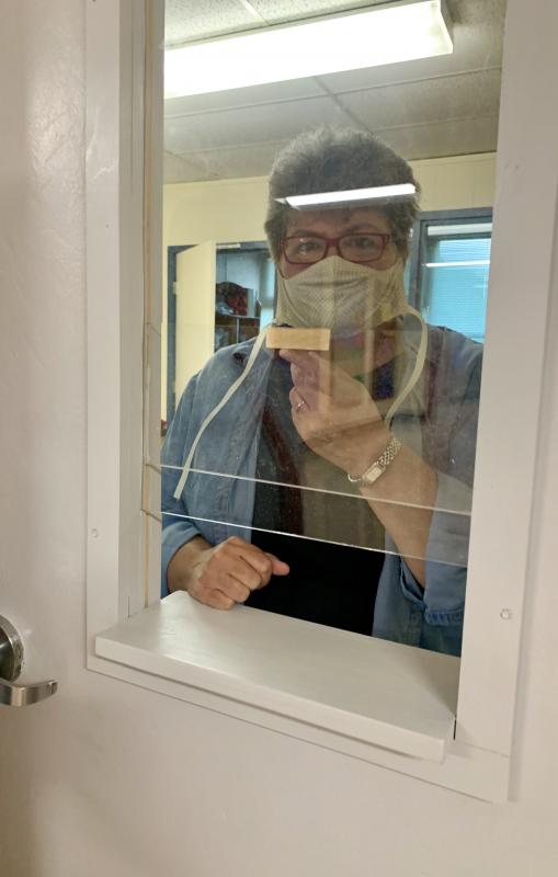 Kristine Cornish, in a mask and behind the new window at the athletic director-assistant principal’s office. SUSAN JOHNS/Wiscasset Newspaper