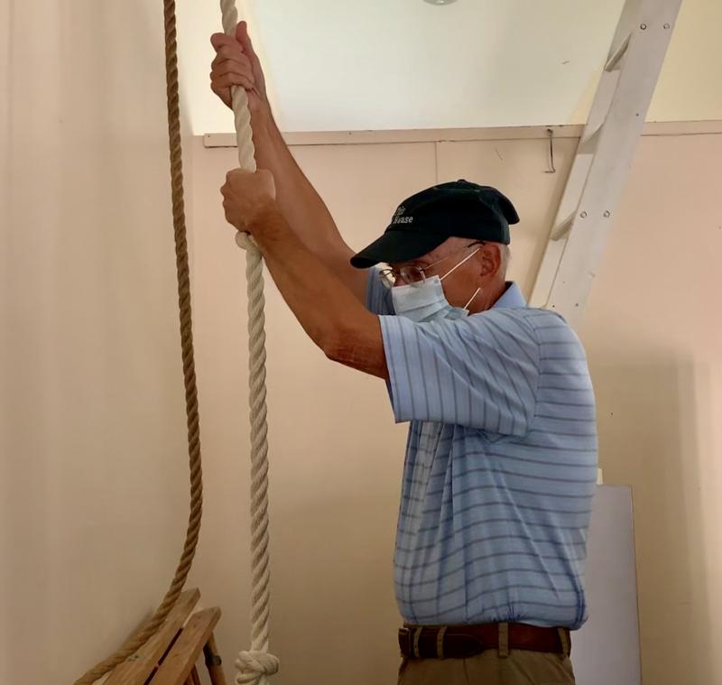 Brad Adler starts the first pull on the rope to ring First Congregational Church’s bell at Sunday’s picnic in Wiscasset. SUSAN JOHNS/Wiscasset Newspaper