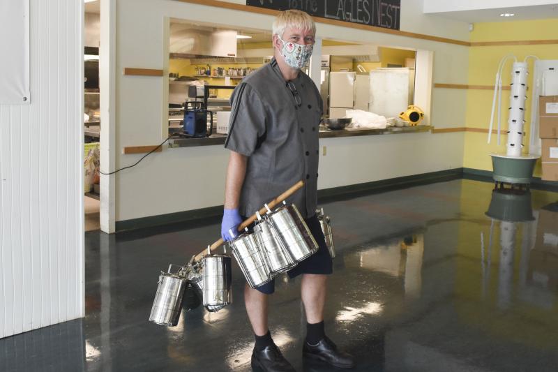 Chef Mikael Andersson collecting LA’s new tiffin boxes after lunch. He uses an old broomstick to collect the tiffins from classrooms, a technique he refers to with a laugh as “old world technology.” Courtesy photo