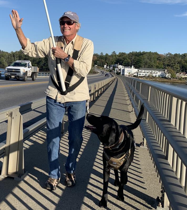 Edgecomb’s Stott Carleton and his black lab Skip take the American flag over Donald E. Davey Bridge and back Monday. SUSAN JOHNS/Wiscasset Newspaper