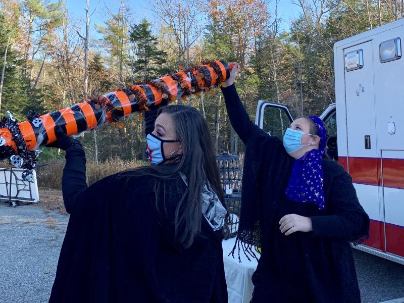 Wiscasset’s interim EMS chief Erin Bean, left, and daughter Phoebe Middleton pass treats through a tube to a carload of trick or treaters Saturday afternoon. SUSAN JOHNS/Wiscasset Newspaper
