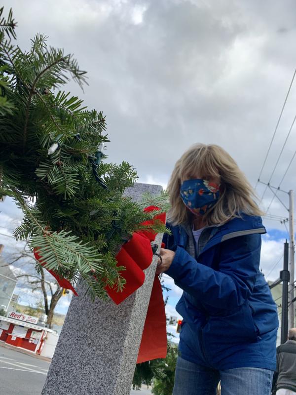 Terri Wells decorates against the backdrop of a Wiscasset sky and, lower left, Red’s Eats. SUSAN JOHNS/Wiscasset Newspaper