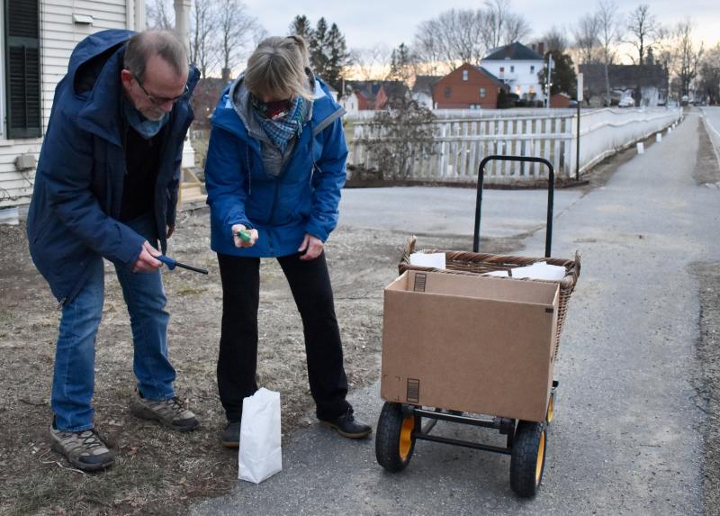 Peter and Terri Wells light candles on Federal Street. PHIL DI VECE/Wiscasset Newspaper