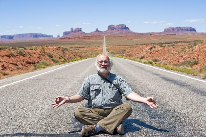 Bob Krist strikes a Buddha, or is it Jerry Garcia, pose to lighten the mood during a video shoot at Monument Valley. Courtesy of Bob Krist