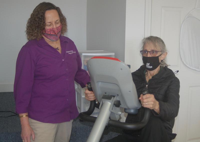 Chamber member Susan Robson tries an exercise machine. ART MAYERS/Wiscasset Newspaper