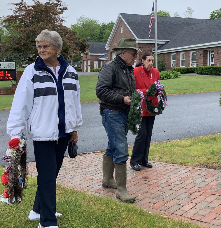 From left, American Legion Post 54 Auxiliary President Sandra Winters, Post 54’s James Quinnam and Daughters of the American Revolution’s Clara Wentworth approach the veterans wall to lay wreaths in Wiscasset Monday. SUSAN JOHNS/Wiscasset Newspaper