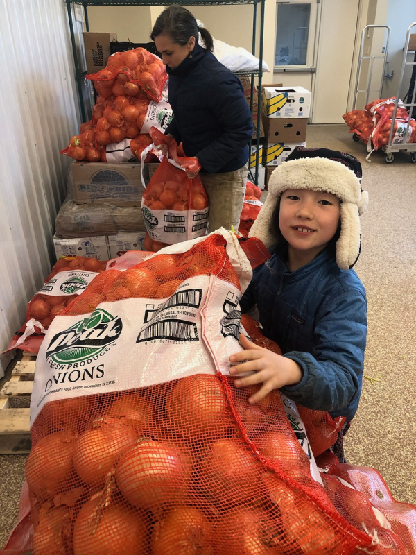 Twin Villages Foodbank Farm co-founder Megan Taft and daughter Adley process a shipment of onions at the food storage hub. Courtesy of Hannah McGhee