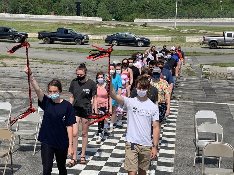 Class marshals Gwen Webber, left, and John Hodsdon lead fellow seniors across the track. SUSAN JOHNS/Wiscasset Newspaper
