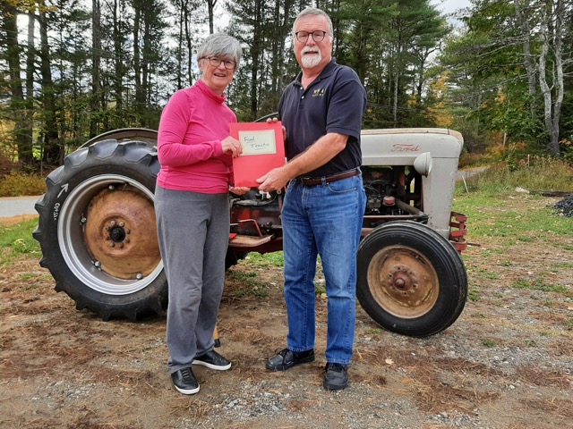 Barbara Bauman, Roland Barth’s wife, hands over the keys of her late husband’s vintage tractor to Wiscasset, Waterville & Farmington Railway Museum President Dave Buczkowski. Courtesy of Doreen Conboy
