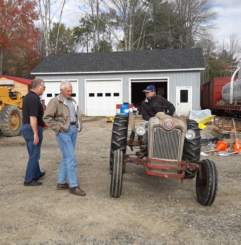 From left, Wiscasset, Waterville & Farmington Railway Museum President Dave Buczkowski and Gordon Davis, a past owner of the Model NAA 1954 Ford tractor, look toward it and Davis’s son Owen, in the driver’s seat. Courtesy of Doreen Conboy