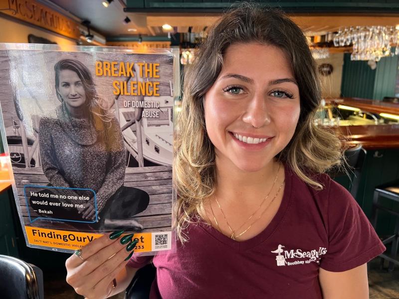 Monique Bertin at McSeagull’s is ready to hang one of the smaller posters there. Patrisha McLean photo