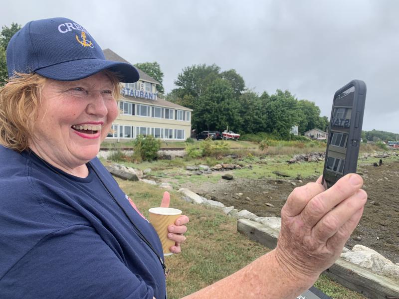 Susan Johns won a third place award for her photo of Jan Flowers looking at a virtual image on her cell phone of Wiscasset’s former schooners, Hesper and Luther Little, during Schoonerfest 2022. File photo