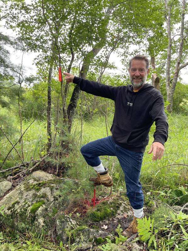 Chris Coombs points to a marker at the corner of the Bristol conservation easement he and his wife Natalie recently donated. Courtesy of Coastal Rivers