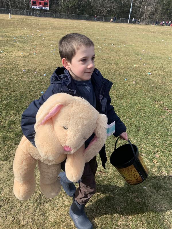 Wiscasset’s Sam Renzi, 8, returns to his family after winning a stuffed bunny at Saturday’s Easter egg hunt at the Wiscasset Middle High School track. SUSAN JOHNS/Wiscasset Newspaper