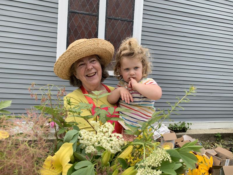 Wiscasset’s Anne Leslie mans a table of flowers with granddaughter Blair Leslie, 2, at St. Philip’s Episcopal Church’s Strawberry Festival June 29. SUSAN JOHNS/Wiscasset Newspaper