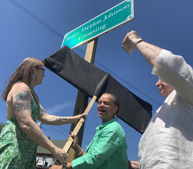 From left, Heather Jones and State Sen. Rachel Talbot Ross unveil one of the new signs naming the Main Street, Wiscasset railroad crossing James Weldon Johnson Crossing, as Terry Heller holds a phone on which Johnson’s great niece Melanie Edwards and Tony Hill, past lawmaker in Johnson’s native Florida, attend via Zoom June 26. SUSAN JOHNS/Wiscasset Newspaper Ceremony