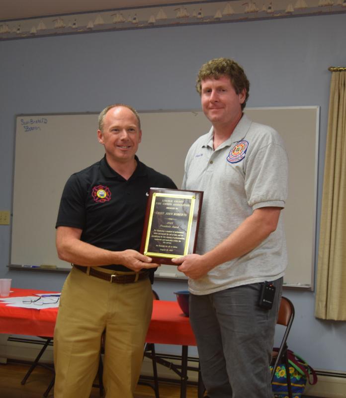 Damariscotta Fire Chief John Roberts, right, receives the 2024 President’s Award from Waldoboro Fire Chief Paul Smeltzer on Wednesday, Aug. 20. Smeltzer said Roberts' commitment to his department while managing the fire academy was among many reasons for his recognition. Christina Wallace photo Roberts