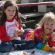 7 year old Hannah Baker, left, and friend and fellow Phippsburg resident Ashley Sloan, 9, snack on fried dough during Sunday's racing. SUSAN JOHNS/Wiscasset Newspaper 
