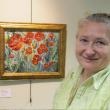 Svetlana Beattie shown with one of her paintings at the FIRST Bank in Boothbay Harbor. 
