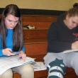 Juniors Abby Dunn, left, and Hannah Campbell work to figure out their future "financial fitness" using the materials and information provided by Maine's Credit Unions. Courtesy of Wiscasset High School