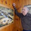 George Jones looks at a painting that hangs in his Wiscasset home: a B-25 on a low flying bombing mission. The painting was done for him by a friend. CHARLOTTE BOYNTON/Wiscasset Newspaper