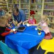 Children's Librarian Judy Flanagan assists in potting the plants at Story Time this past week. The children then gave the potted flowers to the mothers or grandmothers who bring the children to Story Time each week. Courtesy of Wiscasset Public Library