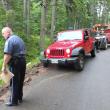 A Jeep Wrangler mail truck is towed out of Appalachee Pond in Boothbay Harbor, as Officer Richard Mirabile examines the accident scene on July 9. RYAN LEIGHTON/Boothbay Register