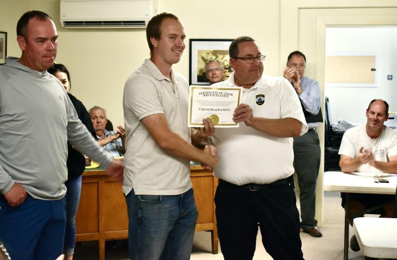 Shown are Woolwich Fire Capt. Brandon Bailey (c) along with Bath Deputy Fire Chief Chris Cummings (r) and Bath Fire Capt. Rick Davis (l). Bailey was recognized for valor and excellence at the scene of a recent fire. PHIL DI VECE/Wiscasset Newspaper