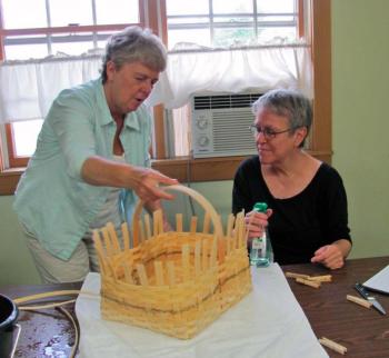 Marè Lemay, demonstrates a basket weaving technique to Mary Hitchcock at Spectrum Generations Coastal Community Center. The next basket-weaving workshop is coming up August 7.