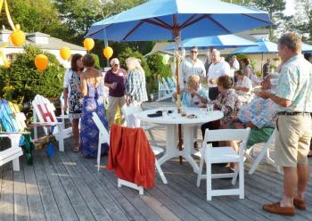 Guests debating their final bids. Bidding was fierce for the chair by artists Susan Brackett and Robert Eisele, below, which sold for $1,000. KATRINA CLARK/Boothbay Register