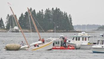 Shipyard workers, Coast Guard personnel and Boothbay Harbor's Harbor Master secured the sailboat which half sunk at its mooring Tuesday afternoon. KEVIN BURNHAM/Boothbay Register