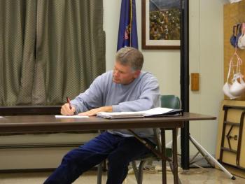Wiscasset Withdrawal member Tim Merry signs the letter to the Department of Education requesting an extension for the withdrawal agreement, which is currently being prepared to withdraw from RSU12. CHARLOTTE BOYNTON/Wiscasset Newspaper