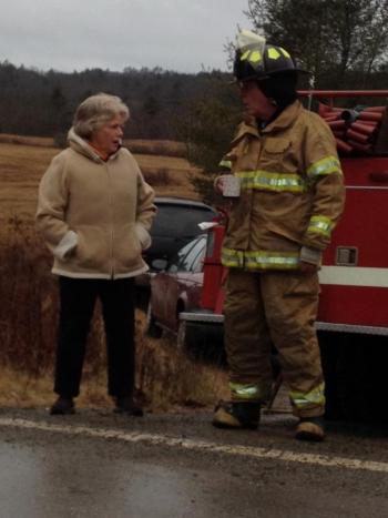 Alna firefighter Jeff Averill, right, has some coffee that Kitty Lipp brought out to emergency workers at the scene. SUSAN JOHNS/Wiscasset Newspaper Alna firefighter Jeff Averill, right, has some coffee that Kitty Lipp brought out to emergency workers at the scene. SUSAN JOHNS/Wiscasset Newspaper