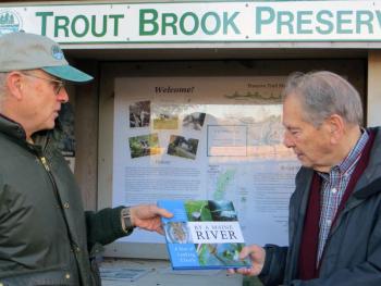 SVCA president John Atwood presents Roy Farmer with a “By a Maine River” book as a token of thanks for his years of service to the association. Courtesy of Sheepscot Valley Conservation Association