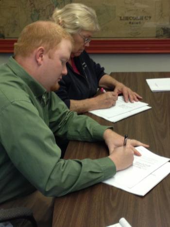 Lincoln County Communications Association President Casey Stevens, left, and Vice President Pam Reed sign a three-year contract for services with the county November 20. JOHN MAGUIRE/Wiscasset Newspaper
