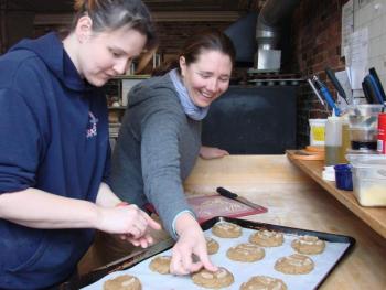 Treats Kitchen Manager Heidi Eastman of Edgecomb, left, and owner Stacy Linehan of Westport Island add crystallized ginger to oven-bound ginger snaps at the Wiscasset business. The store will make heart-shaped snaps for Valentine's Day. SUSAN JOHNS/Wiscasset Newspaper