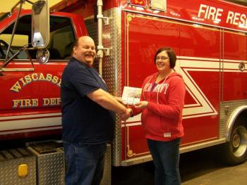 Wiscasset Fire Chief Ron Bickford congratulates Amanda Cloutier, the grand prize winner of the NASCAR race tickets, sponsored by the Association of Wiscasset Firefighters. Courtesy of the Association of Wiscasset Firefighters