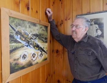 George Jones looks at a painting that hangs in his Wiscasset home: a B-25 on a low flying bombing mission. The painting was done for him by a friend. CHARLOTTE BOYNTON/Wiscasset Newspaper