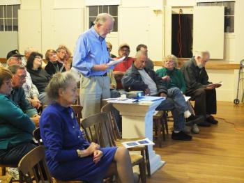 Wright committee member Richard DeVries presented a signed petition asking the town to hold the Wright property “in perpetuity” for public use. In the foreground is Ann Dowrick, who currently lives in the Wright house and pays rent to the town. JOHN MAGUIRE/Wiscasset Newspaper