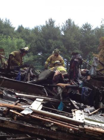 Dresden and Richmond firefighters sort through debris June 30 following a rekindle of the fire that destroyed this Cedar Grove Road, Dresden, home a day earlier. SUSAN JOHNS/Wiscasset Newspaper
