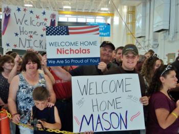 The Greenleaf and Leighton families hold signs welcoming their soldiers home from Afghanistan. Courtesy of Isaac Luken The Greenleaf and Leighton families hold signs welcoming their soldiers home from Afghanistan. Courtesy of Isaac Luken