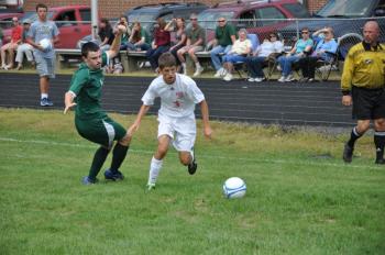 Wiscasset’s J.D. Souza, right, fights with a Carrabec defender for possession of the ball deep in Carrabec territory. Despite his aggressive first half, Wiscasset was unable to score on senior Cobra goalie Trent Richardson. The two teams tied, 0-0, to open the season. BEN BULKELEY/Wiscasset Newspaper