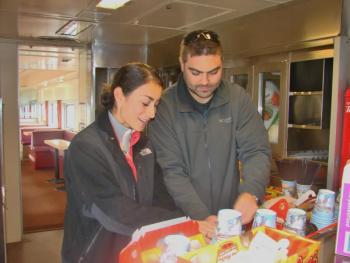 Chanterelle Atkins, left, of Wiscasset and husband Kevin Atkins check out the festive treats aboard the Maine Eastern Railroad's Toys ‘n’ Turkeys Train, during its Wiscasset stop. The special train run on November 16 was a food and toy drive. The local couple donated frozen turkeys. SUSAN JOHNS/Wiscasset Newspaper Wiscasset couple on Maine Eastern Railroad train