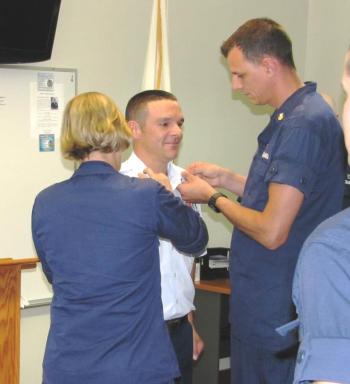 Rear Admiral Linda Fagan, newly appointed Commander of USCG First District, assisted by Petty Officer First Class Jessie Ellison, pins the Boatswains Mate First Class collar devices on just advanced station member Tony Shumpert. In addition to the pinning on of the new collar devices, the ceremony includes the reading of the Advancement Certificate which was done by Commander of CG Sector Northern New England Capt. Brian Gilda. Courtesy of Ted Chatham/USCG Auxiliary
