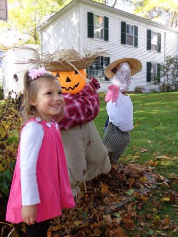 Addison West stands with the library’s new scarecrow creations. Courtesy of Natalie Castonia