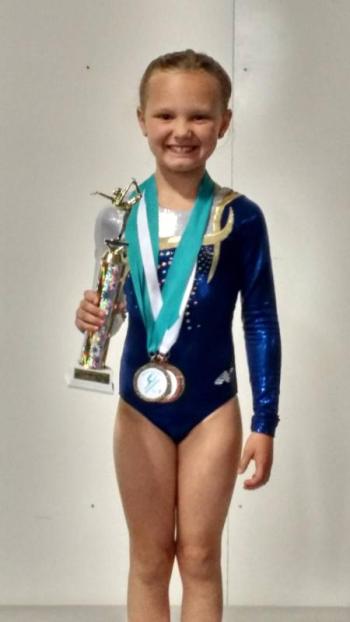Kadence Rogers climbs to the top of the podium as Northeast Regional Champion level 3. Courtesy of Michael Johnson