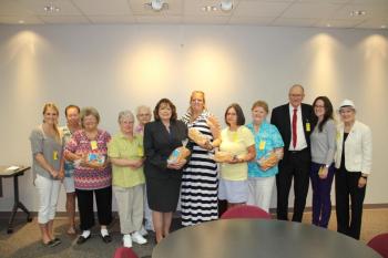 Vicki Stuart (center, dark suit, holding a loaf of bread in her arms), chair of the Maine Credit Union League’s Social Responsibility Committee, which coordinates the Maine Credit Unions’ Campaign for Ending Hunger, stands with representatives from Good Shepherd Food Bank and some of the food pantries that received contributions through the Campaign’s Share the Bread event. Courtesy photo
